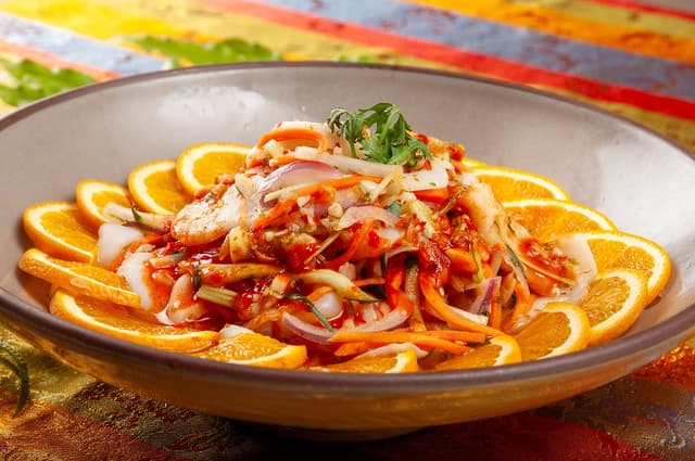 「泰式涼拌花枝沙拉」以新鮮彈牙的花枝搭配爽脆蔬菜，淋上泰式酸辣醬汁，每一口都是夏日輕盈享受。／台北凱撒大飯店提供